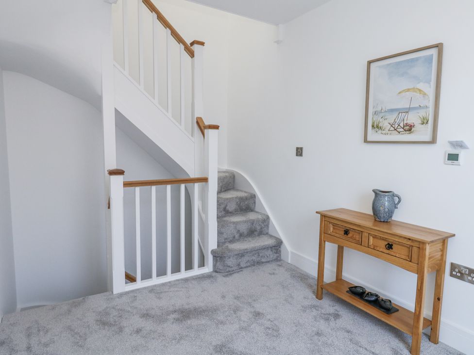 A hallway with a staircase and a console table at Seafern House 36B in Poole