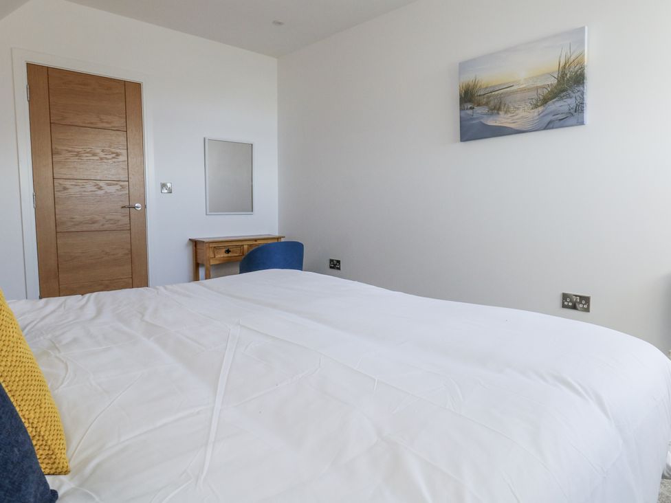 A bedroom with a bed and wooden furniture at Seafern House 36B in Poole