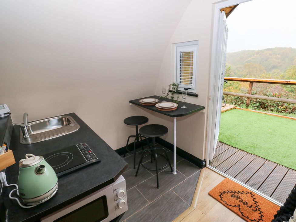 A kitchen with a sink and dining area at Cwtch Bach in Aberdare