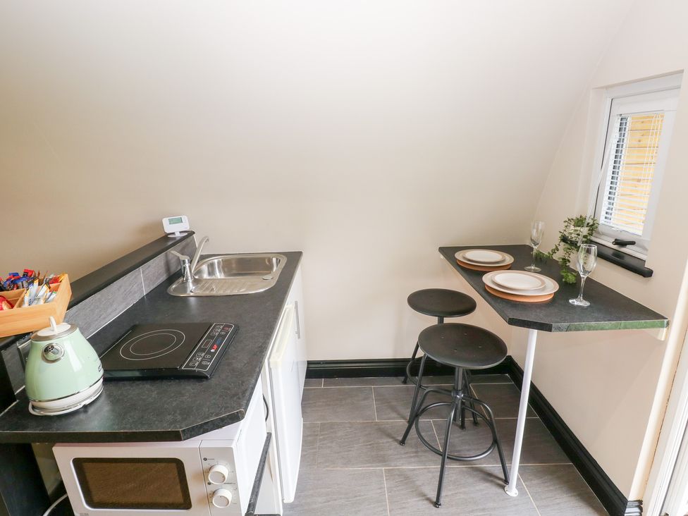 A kitchen with a stove and sink at Cwtch Bach in Aberdare