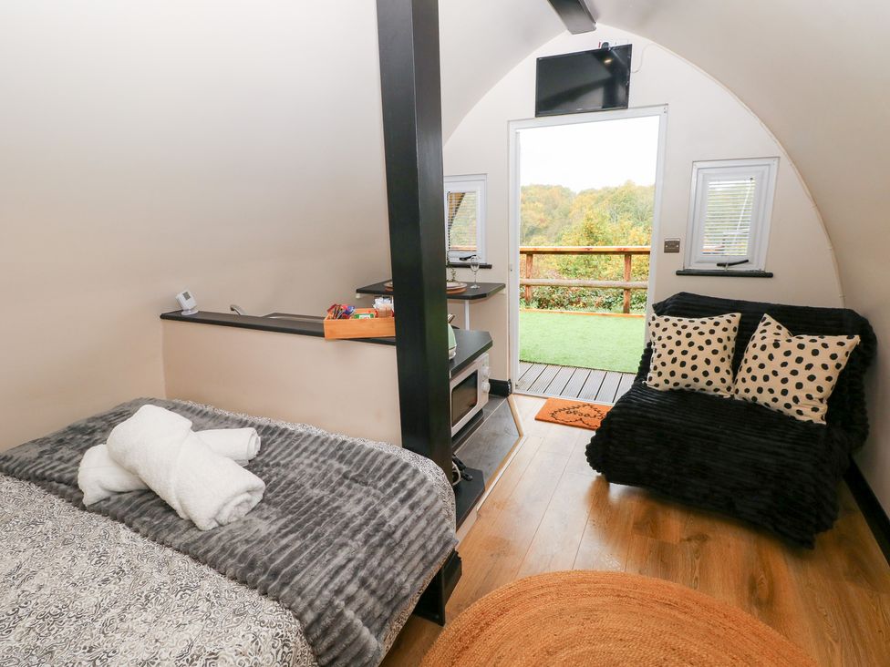 A bedroom with a bed and sofa at Cwtch Bach in Aberdare