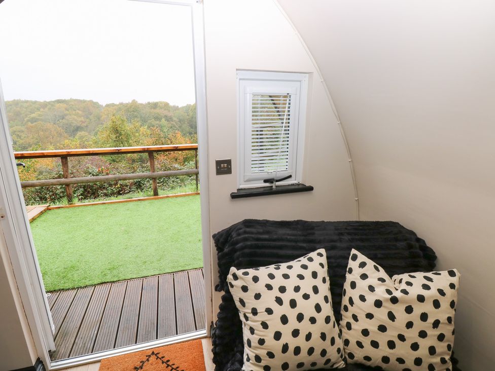 A living room with a view of trees and a deck at Cwtch Bach in Aberdare