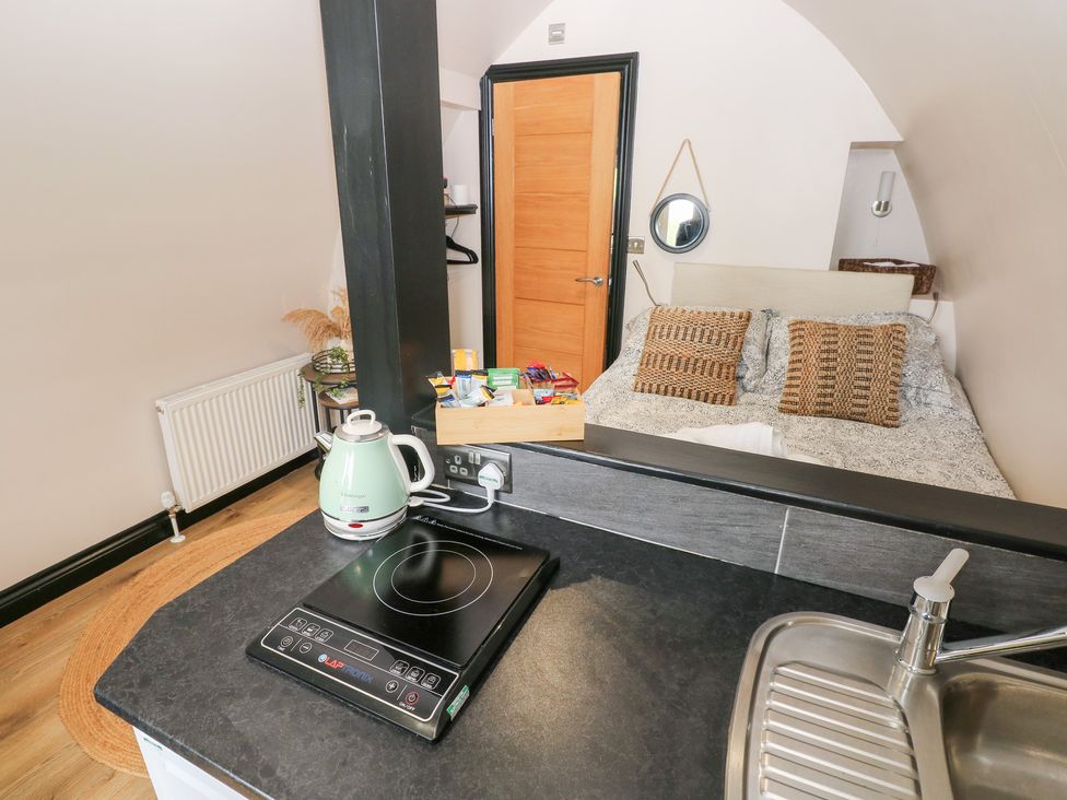 A studio with a kitchenette and bed at Cwtch Bach Aberdare