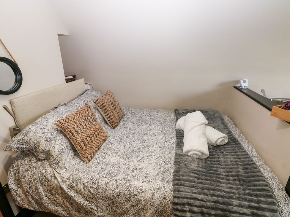 A bedroom with a bed and towels at Cwtch Bach in Aberdare