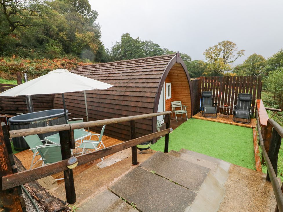 An outdoor area with a hot tub and seating at Cwtch Bach in Aberdare