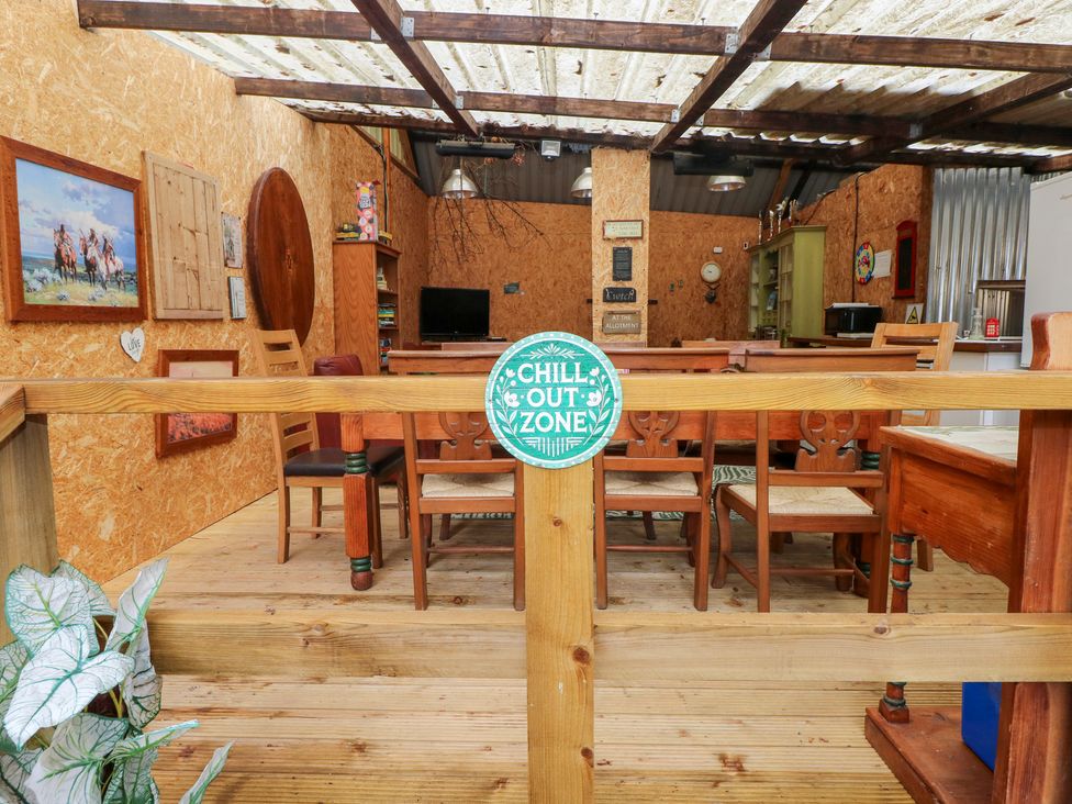 An outdoor seating area with tables and chairs at Cwtch Bach Aberdare