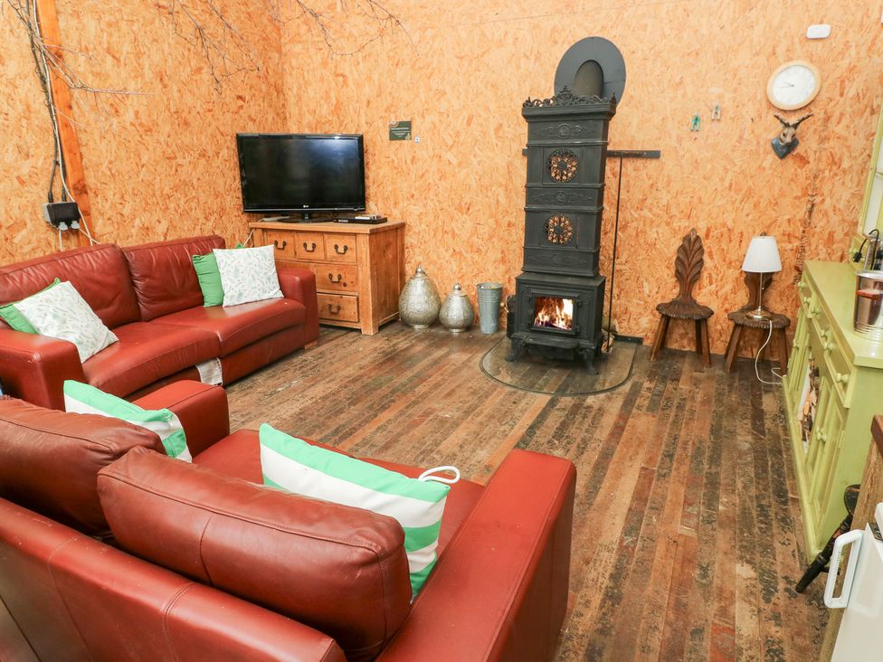 A living room with a sofa and fireplace at Cwtch Bach in Aberdare