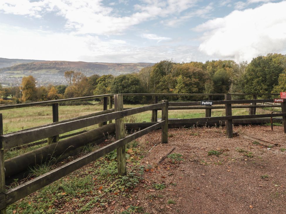 An outdoor area with a fence and parking signs at Cwtch Bach Aberdare
