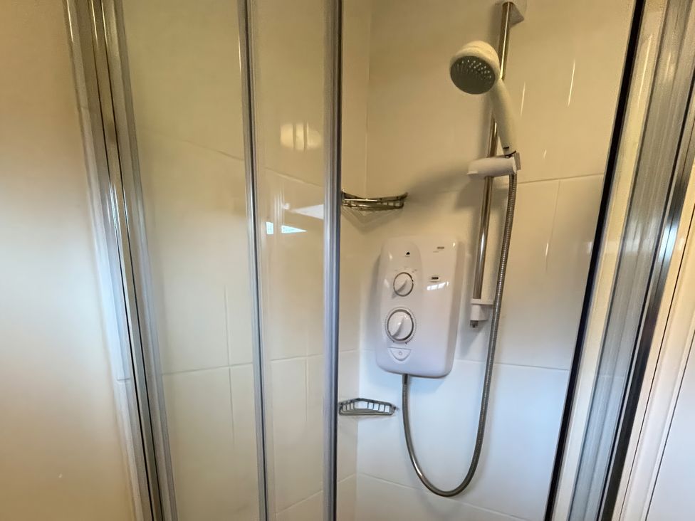 A shower with a glass enclosure and a shower valve at Stanbury
