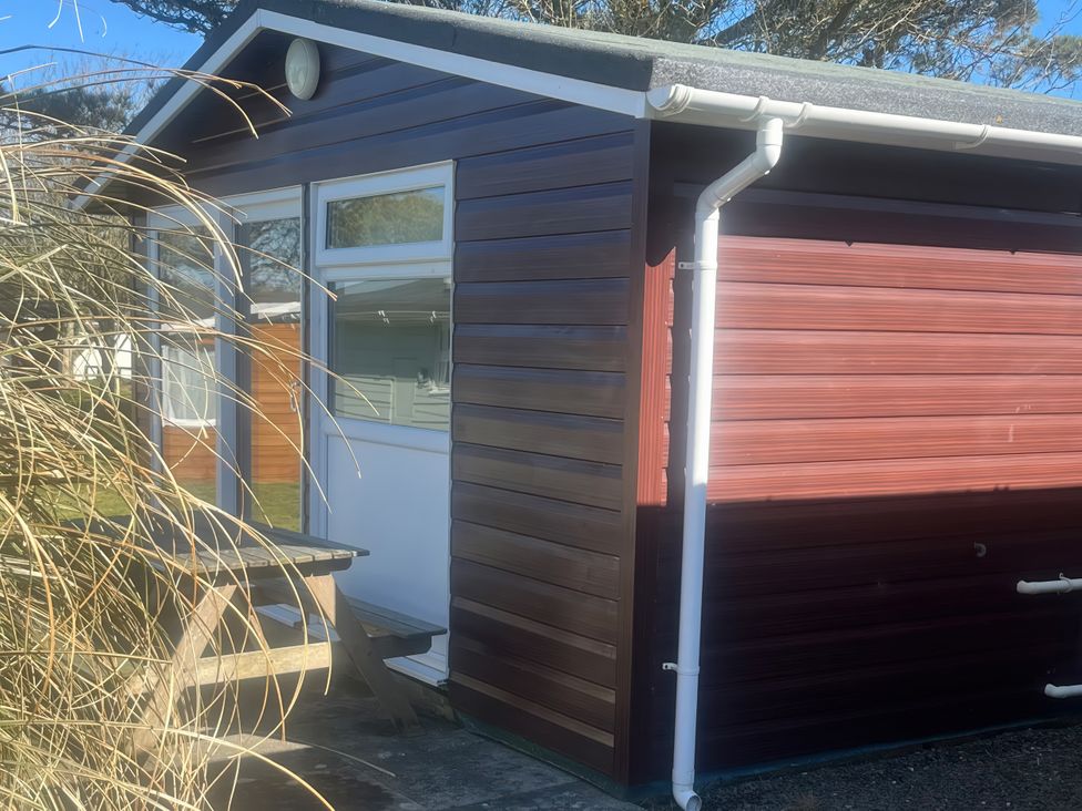 A wooden building with a table outside at Stanbury