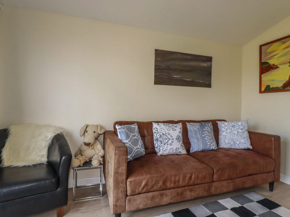 A living room with a sofa and armchair at Stanbury in St Merryn