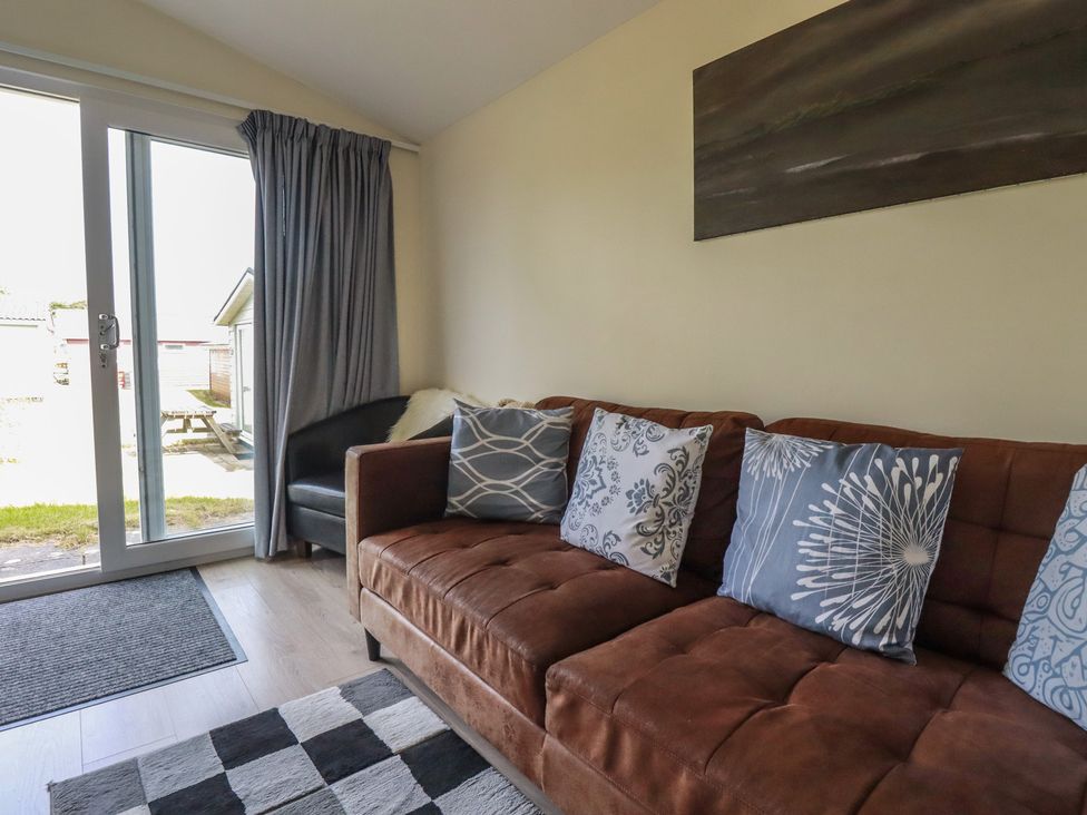 A living room with a sofa and pillows at Stanbury in St Merryn