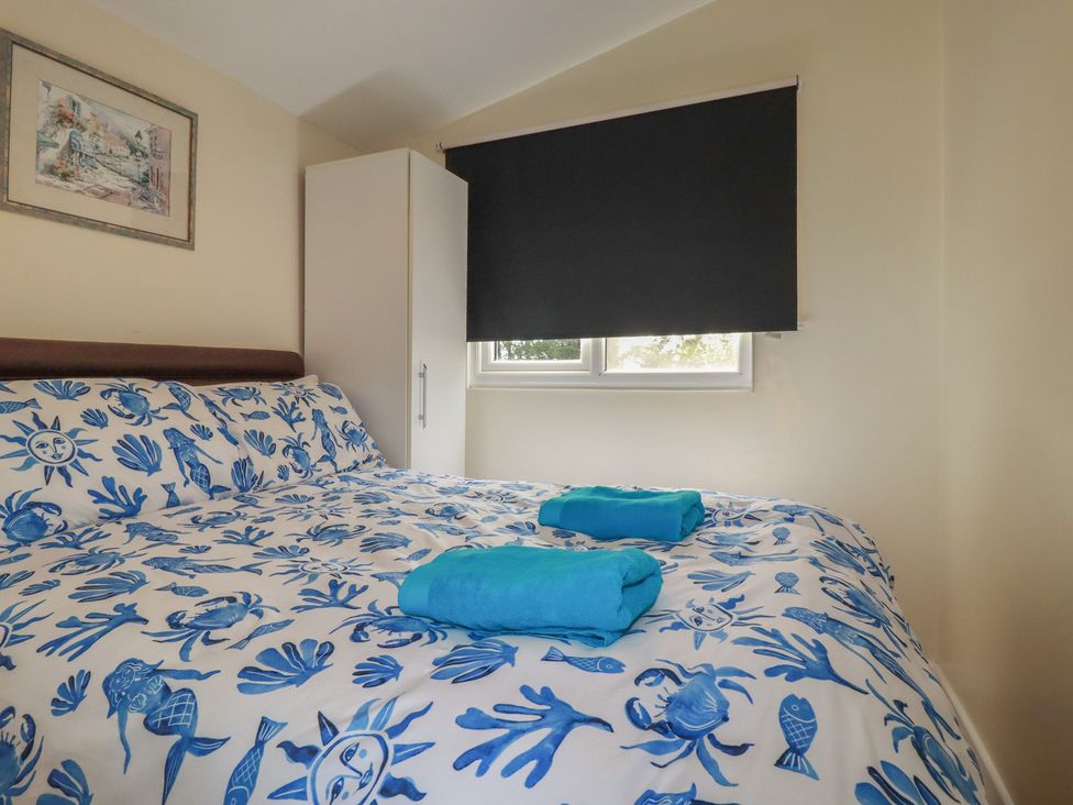 A bedroom with a bed and wardrobe at Stanbury in St Merryn