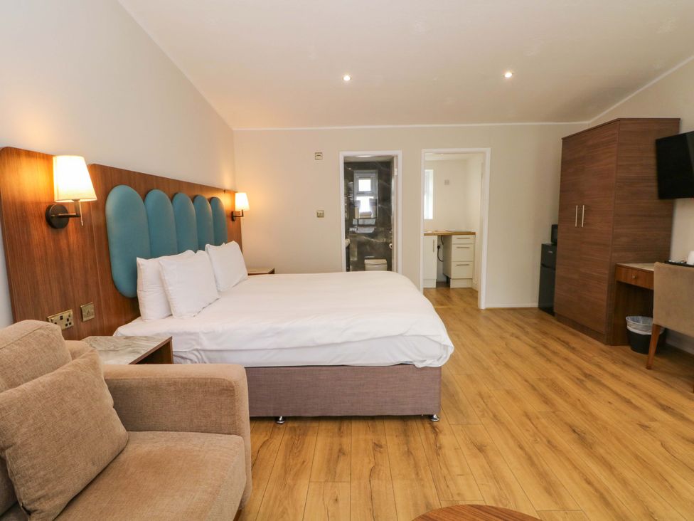 A bedroom with a bed and kitchenette at 1 bed no. 1