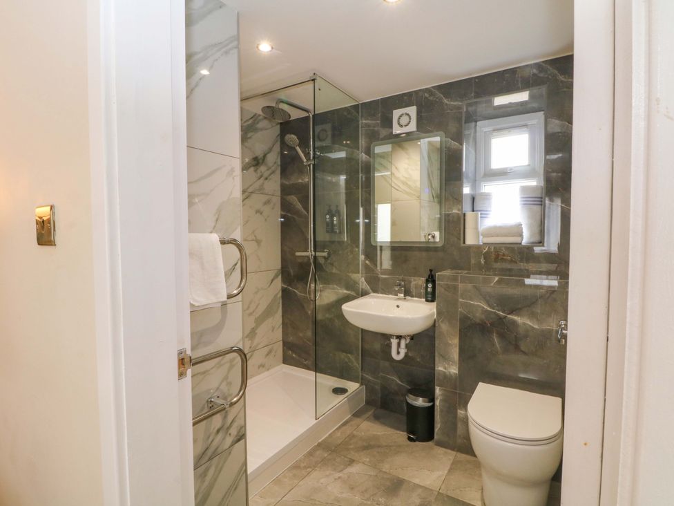 A bathroom with shower, sink, and toilet at 1 bed no. 1