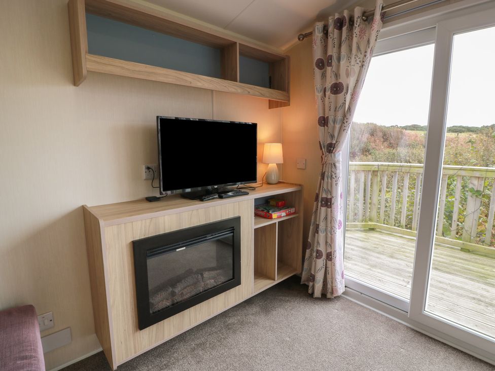 A living room with a television and fireplace at Peaceful in Stranraer