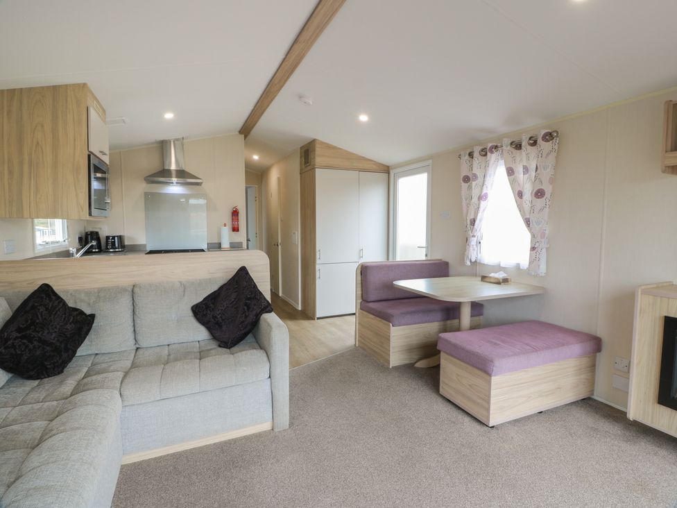 A living room with a sofa and dining table at Peaceful in Stranraer