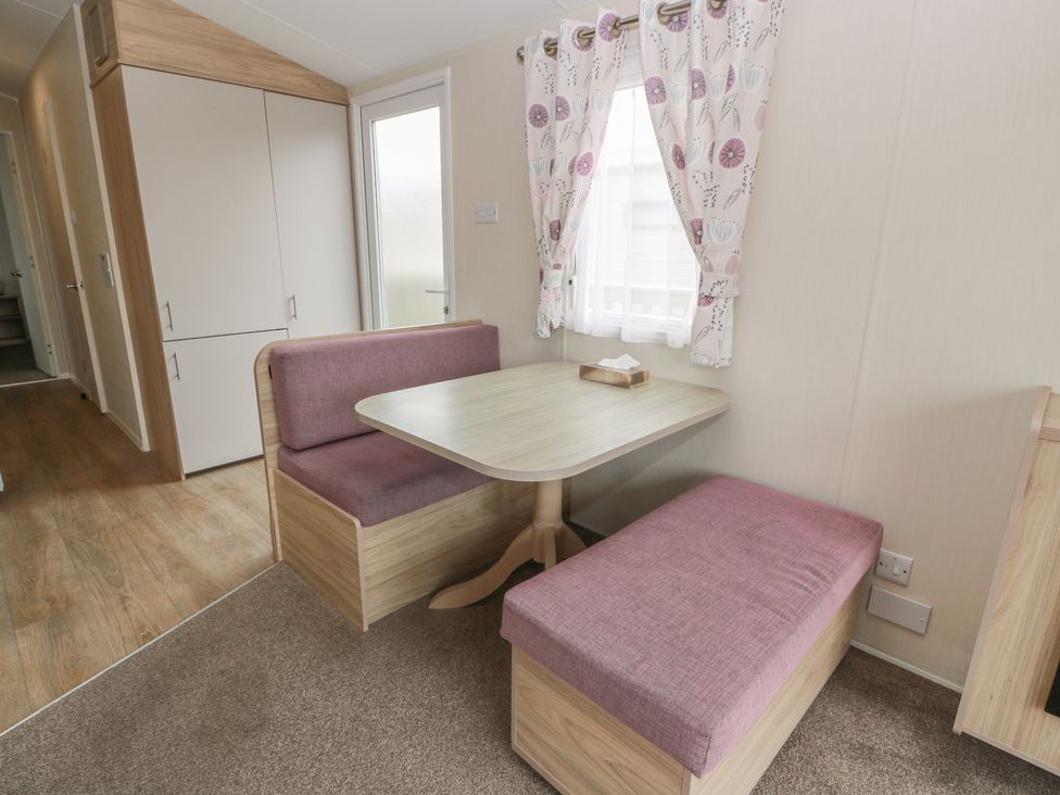 A dining area with a table and benches at Peaceful in Stranraer