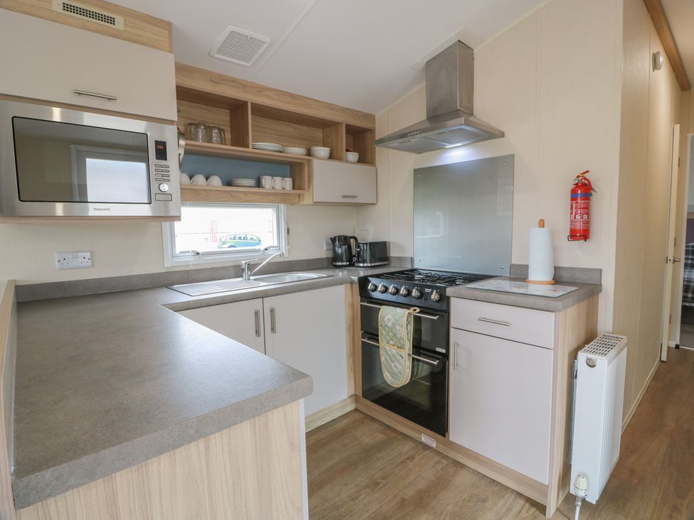 A kitchen with a stove and microwave at Peaceful in Stranraer