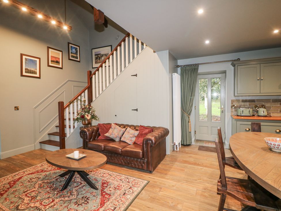 A living room with a staircase and a dining area at Robins Rest at The Lodge Kilmacthomas