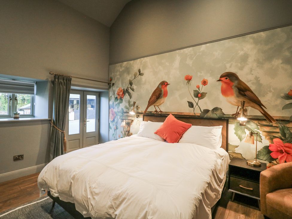 A bedroom with a bed and wall art at Robins Rest at The Lodge in Kilmacthomas