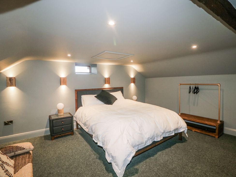 A bedroom with a bed and a clothes rack at Robins Rest at The Lodge in Kilmacthomas
