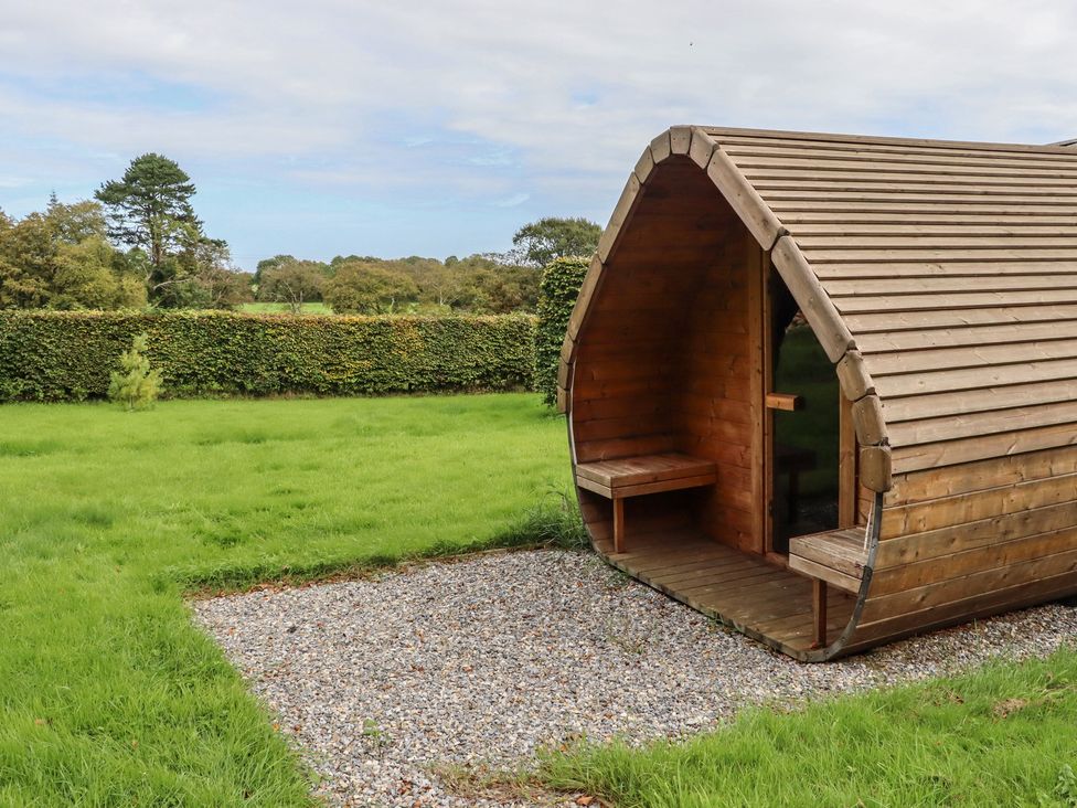 A wooden cabin with a gravel path in a grassy area at Robins Rest at The Lodge Ahanaglogh near Kilmacthomas, County Waterford