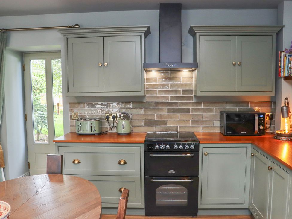 A kitchen with cabinets, an oven, and a microwave at Robins Rest at The Lodge Ahanaglogh near Kilmacthomas, County Waterford