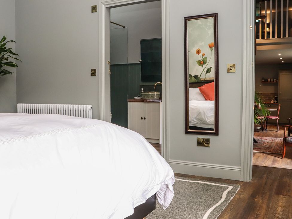 A bedroom with a bed and a mirror at Robins Rest at The Lodge in Ahanaglogh near Kilmacthomas, County Waterford