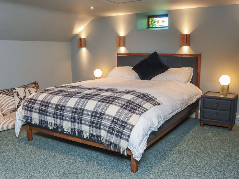 A bedroom with a bed, bedside table, and lamp at Robins Rest at The Lodge, Ahanaglogh near Kilmacthomas, County Waterford