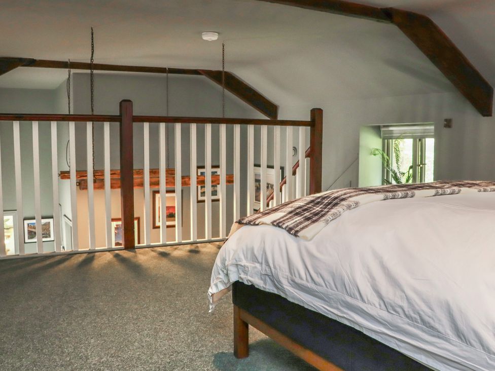 A bedroom with a bed and railing overlooking a staircase at Robins Rest at The Lodge Ahanaglogh near Kilmacthomas, County Waterford