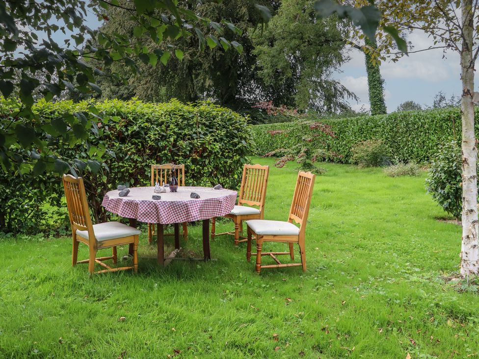 A table with chairs in a garden at Robins Rest at The Lodge Ahanaglogh near Kilmacthomas, County Waterford