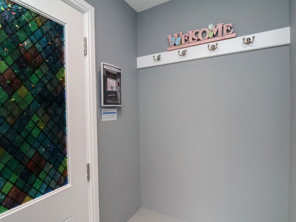 An entryway with a welcome sign and hooks at Arthur's House in Middlesbrough
