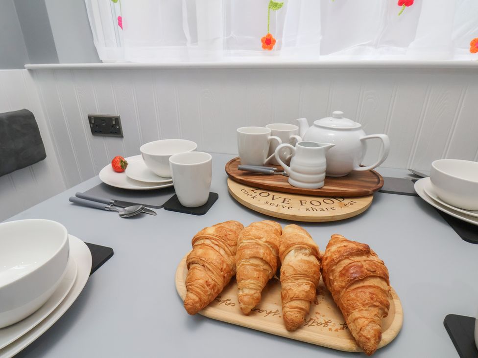 A kitchen table set with croissants, teapot, and cups at Arthur's House in Middlesbrough