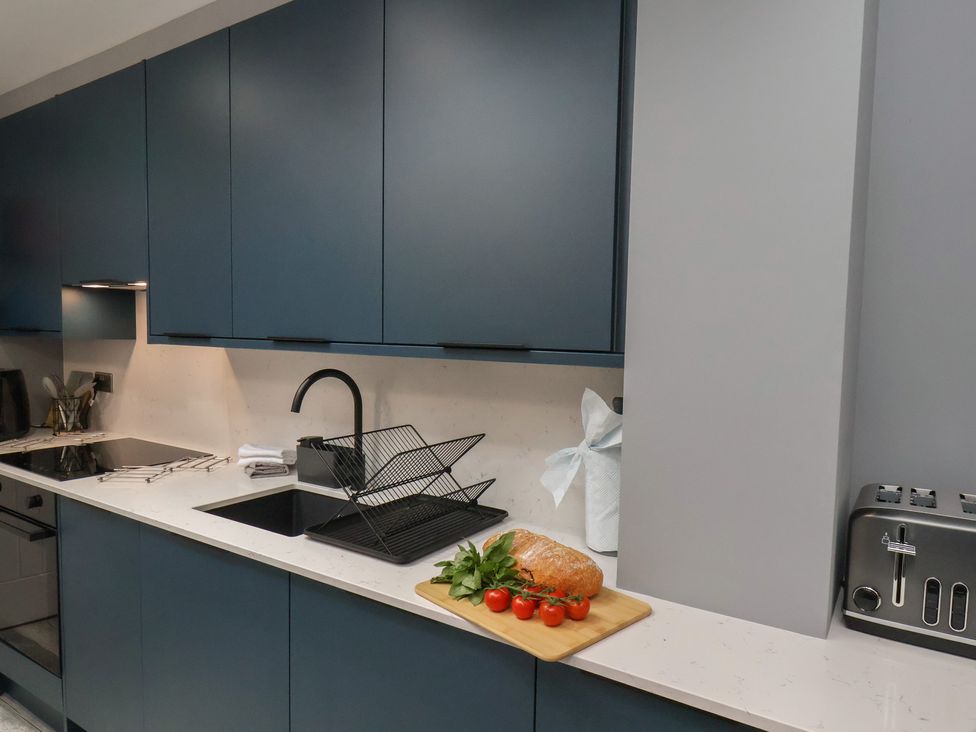 A kitchen with a sink and cutting board at Arthur's House in Middlesbrough