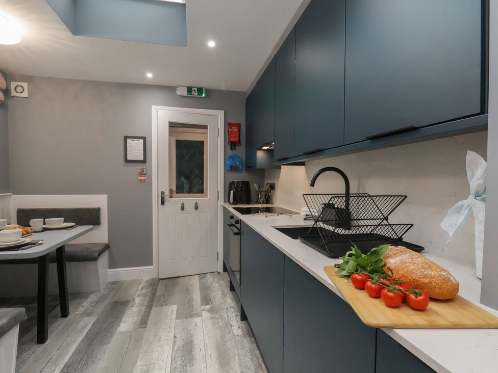 A kitchen with a table and chairs and food items at Arthur's House in Middlesbrough