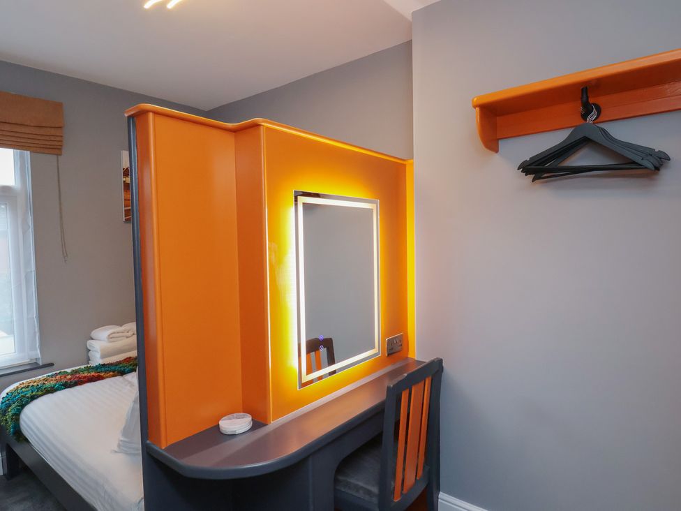 A bedroom with a mirror and a vanity table at Arthur's House in Middlesbrough