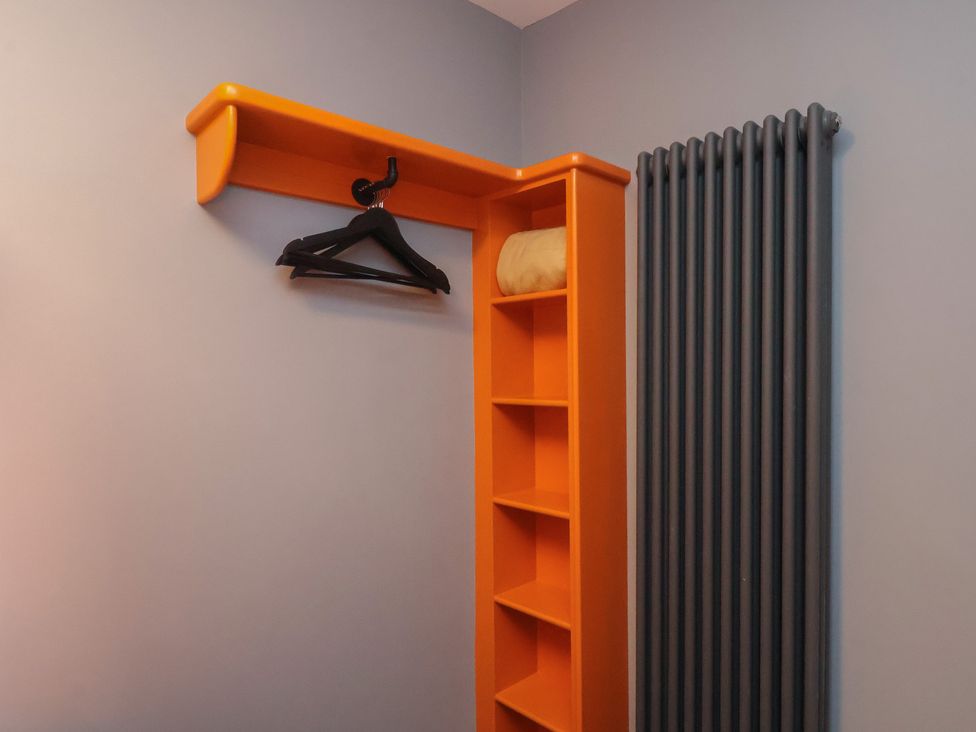 A shelf with a coat hanger and blanket in a bedroom at Arthur's House in Middlesbrough