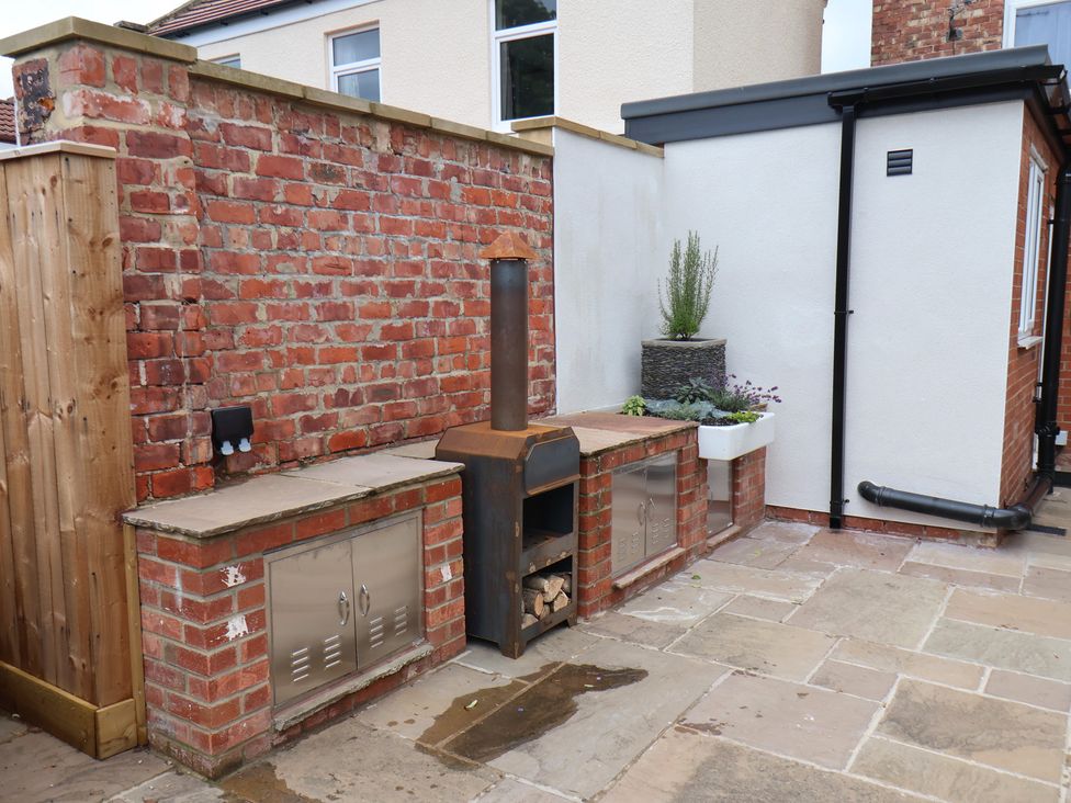 A garden area with a brick wall and an outdoor stove at Arthur's House in Middlesbrough