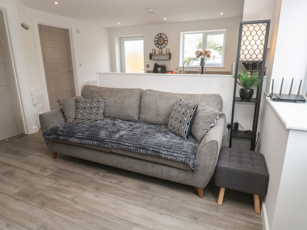 A living room with a couch and table at Cosy Retreat