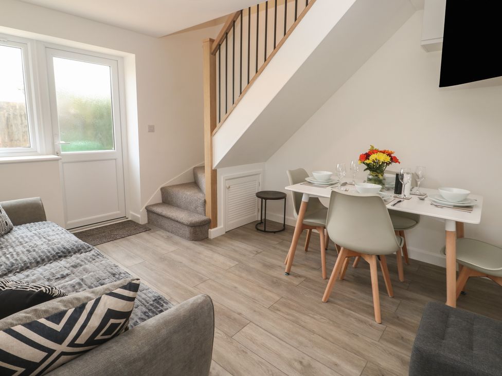 A dining area with a table and chairs adjacent to a sofa at Cosy Retreat 