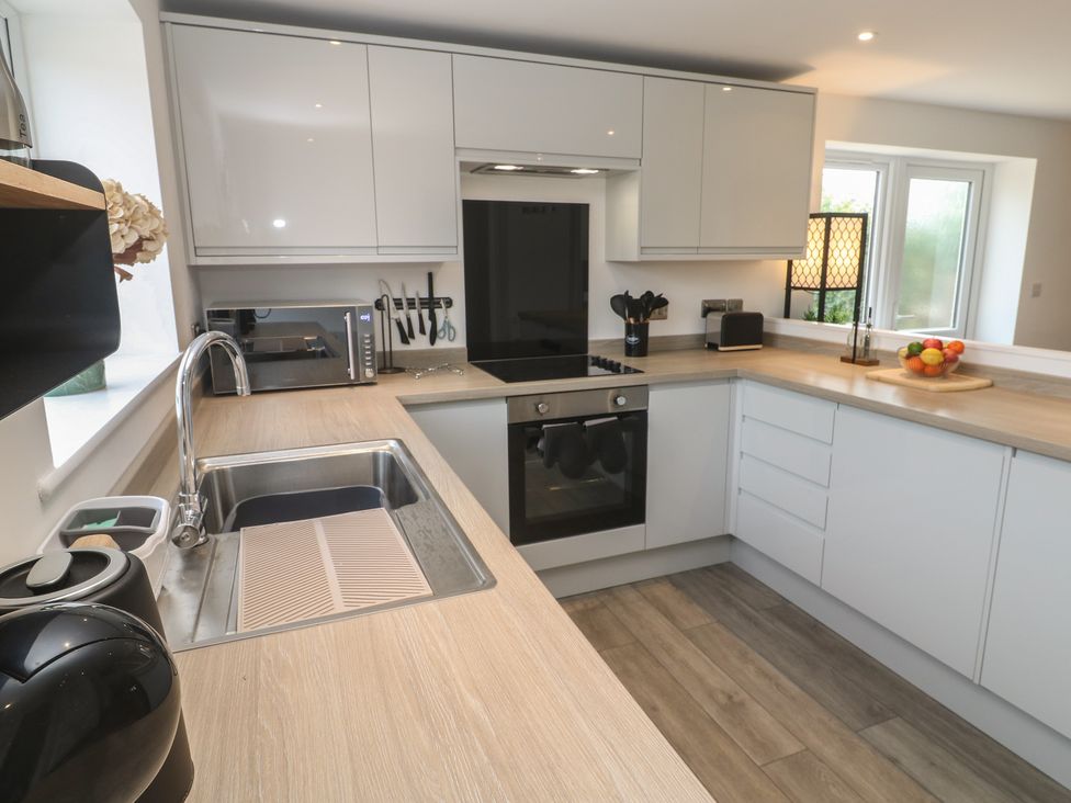 A kitchen with modern appliances and utensils at Cosy Retreat