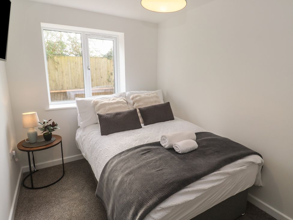 A bedroom with a bed and side table at Cosy Retreat 