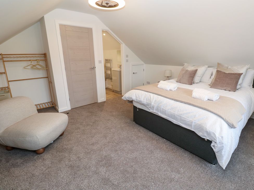 A bedroom with a bed and a chair at Cosy Retreat