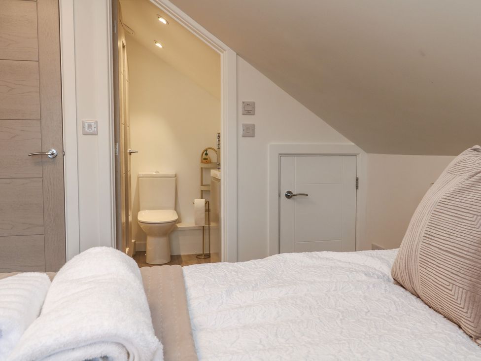 A bedroom featuring a bed and an adjoining bathroom at Cosy Retreat 
