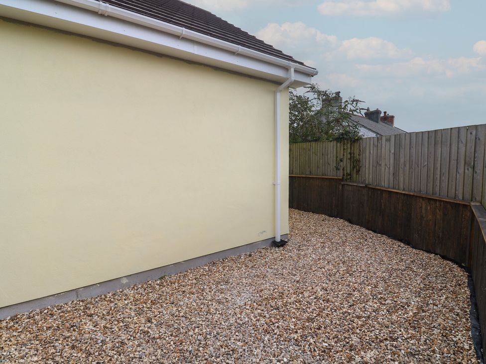 An outdoor area with gravel and a yellow wall at Cosy Retreat