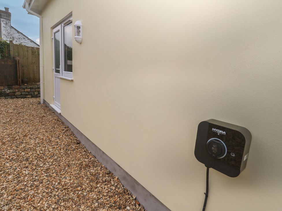 An exterior wall with an electric meter and gravel ground at Cosy Retreat in 