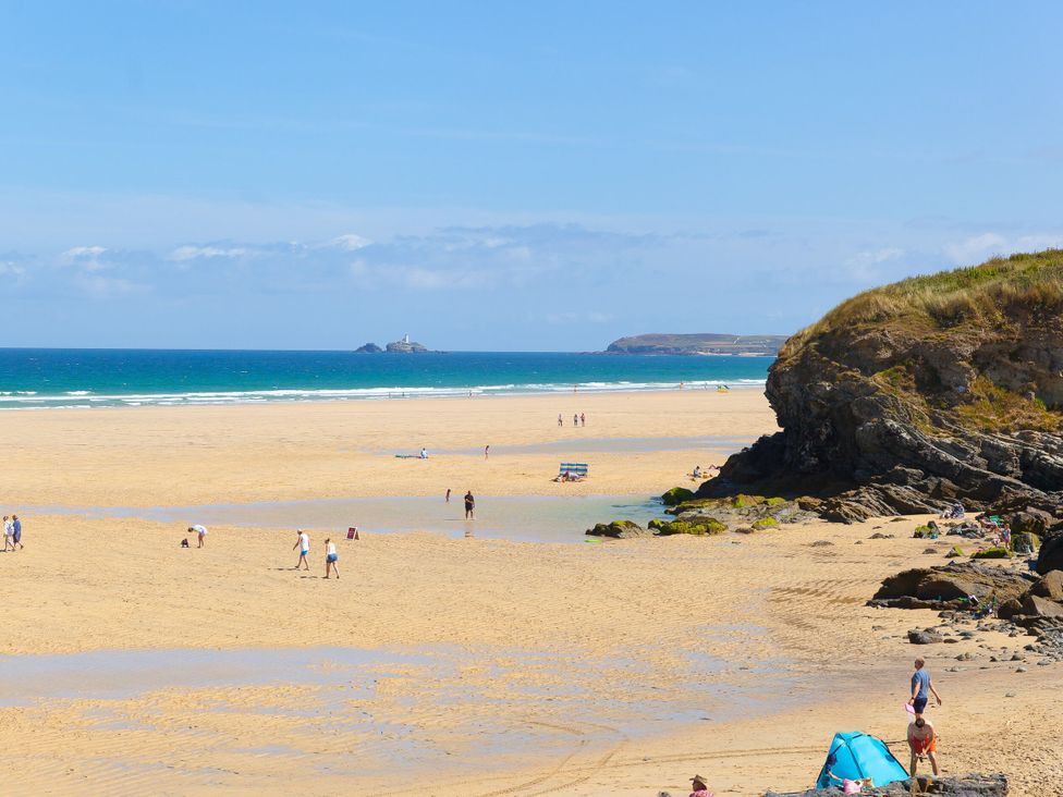 A beach with people and rocks at Cosy Retreat