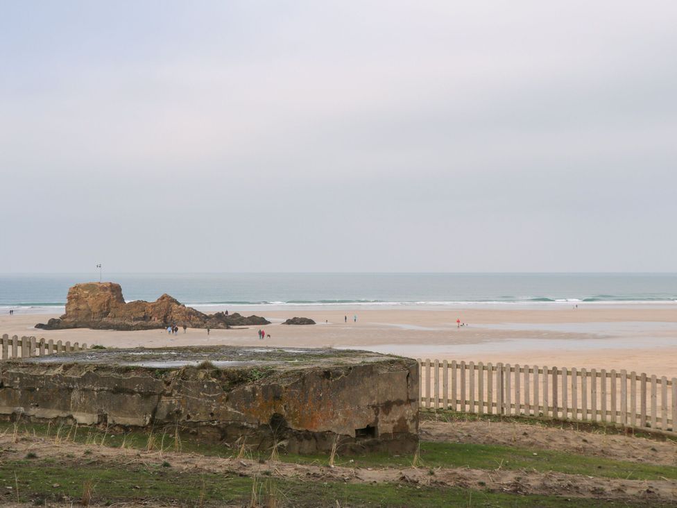 A beach scene with people walking near water at Cosy Retreat in 