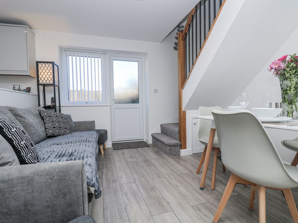 A living room with a sofa and dining area at Cosy Retreat in Pool